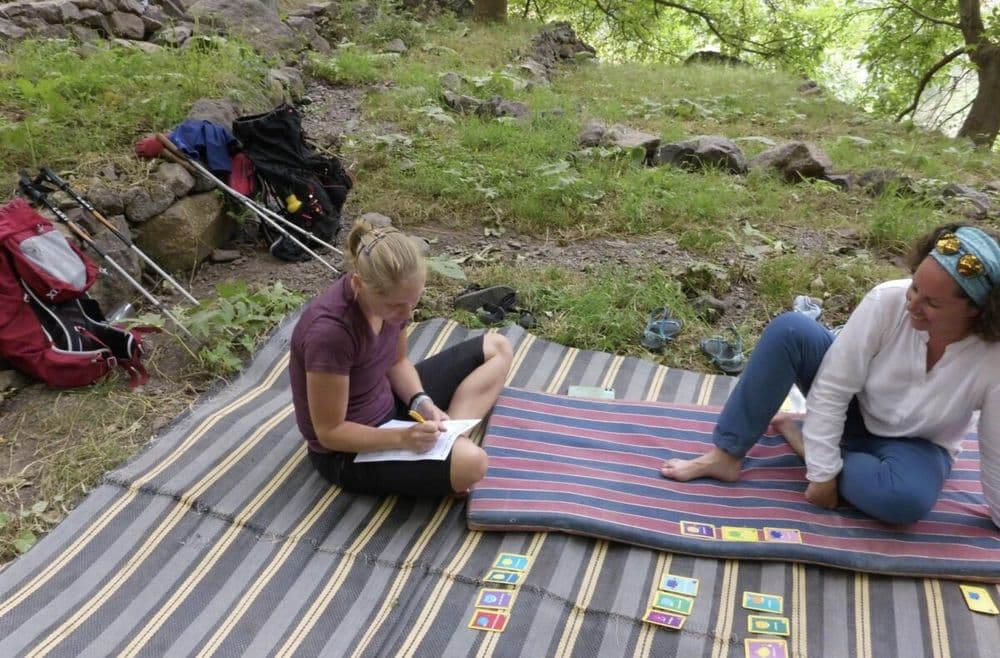 Coachinggesprek op een tapijt in de natuur tijdens een groeireis